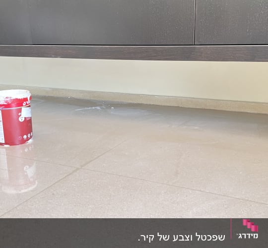 פח צבע על רצפה ליד קיר